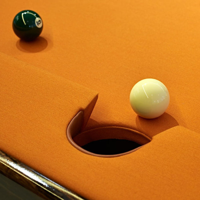 Close-up of orange felt MBM Biliardi B_ig Pool Table pocket detail with cue and object balls, highlighting premium play surface.
