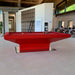 MBM Biliardi B_ig Pool Table in bold red finish with minimalist base, featured in a contemporary open-plan workspace with a modern interior aesthetic.