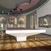 Front view of MBM Biliardi B_ig Pool Table in sleek white finish with blush pink felt, positioned beneath a curved ceiling and baroque chandelier.