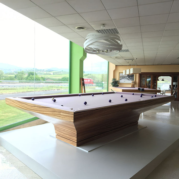 MBM Biliardi B_ig Pool Table with light wood finish and lavender felt, displayed in a bright, modern showroom with scenic views.