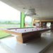 MBM Biliardi B_ig Pool Table with light wood finish and lavender felt, displayed in a bright, modern showroom with scenic views.