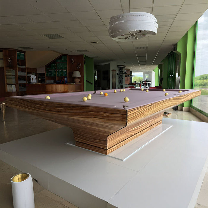 Side view of MBM Biliardi B_ig Pool Table featuring premium zebrawood finish and pastel purple felt in a luxurious interior.