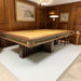 MBM Biliardi Kyoto luxury billiard table with yellow cloth in elegant wood-panelled room.