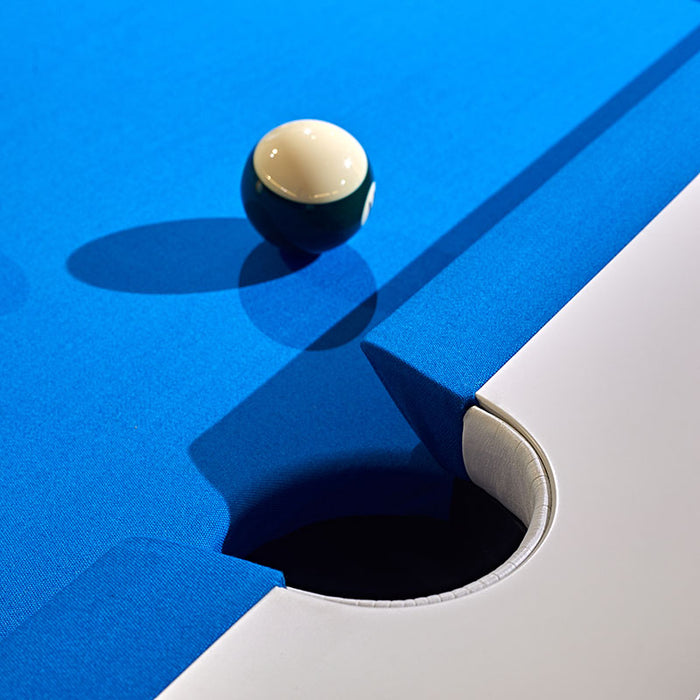 Close-up of MBM Biliardi Stealth pool table corner pocket with blue felt surface, featuring yellow-white and green-white billiard balls in play.