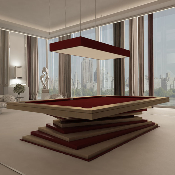 An elegant beige and red MBM Biliardi Ziggurat pool table in a luxurious apartment with floor-to-ceiling windows overlooking a cityscape.