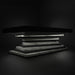 A dramatic low-angle render of the MBM Biliardi Ziggurat pool table with a black frame and a spiraling white marble-effect base, set against a dark background.