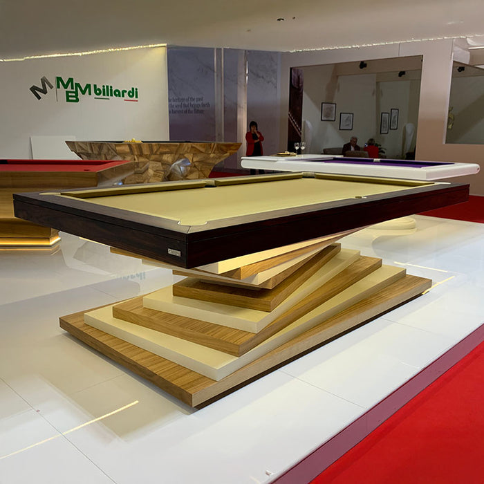 A sleek black and white MBM Biliardi Ziggurat pool table on display in a modern showroom with the MBM Biliardi logo in the background.