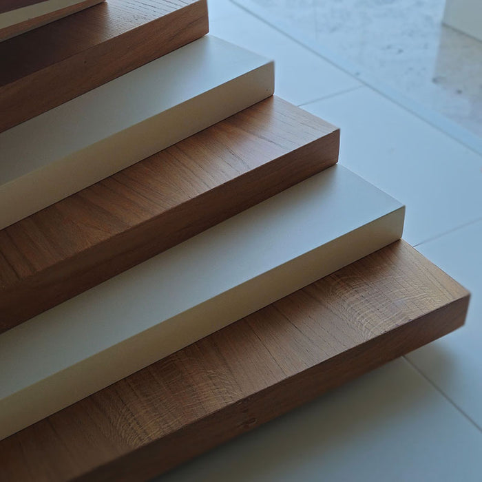 A detailed close-up shot of the MBM Biliardi Ziggurat pool table's base, emphasizing the quality and alternating pattern of the wood and white layers.