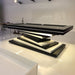 A sleek MBM Biliardi Ziggurat pool table in black and white, featuring a spiraling base design and a black felt surface.