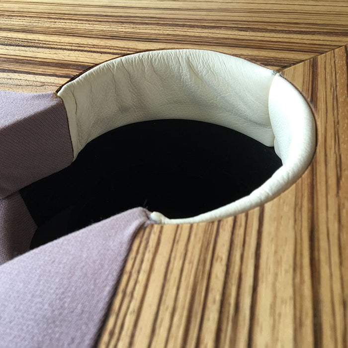 A close-up detail of a pocket on an MBM Biliardi Ziggurat pool table, showcasing the wood grain, cream-colored leather, and lilac felt.