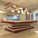 A luxurious MBM Biliardi Ziggurat pool table in red and white, featured in an elegant home interior with a unique spherical chandelier.