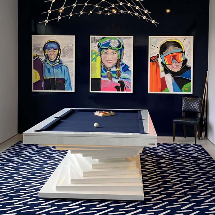 A stylish white MBM Biliardi Ziggurat pool table with a blue felt surface, featured in a modern home entertainment space with contemporary art.