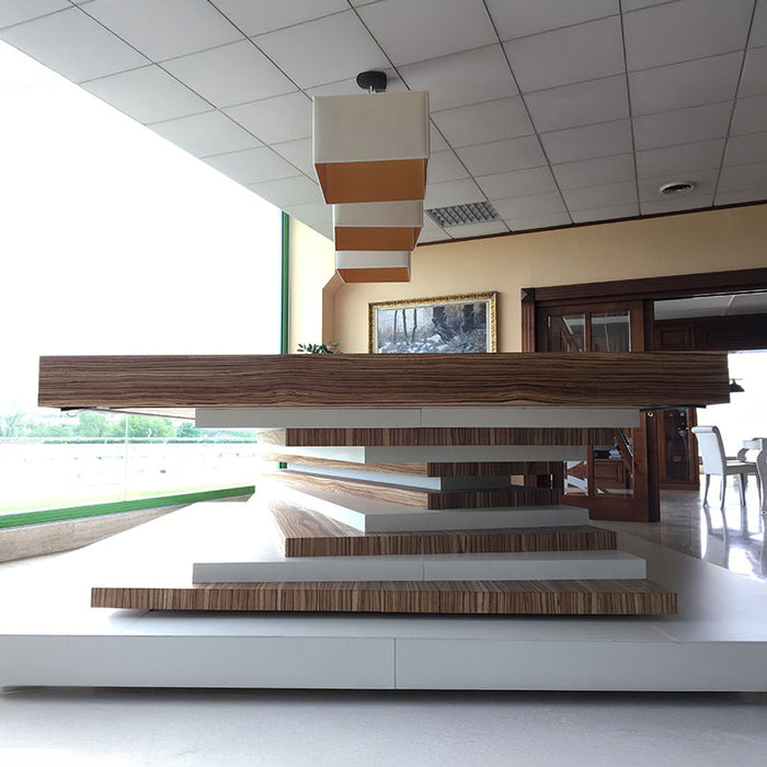 Side view of an MBM Biliardi Ziggurat pool table featuring its distinctive wood and white stacked base in a contemporary interior with pendant lights.