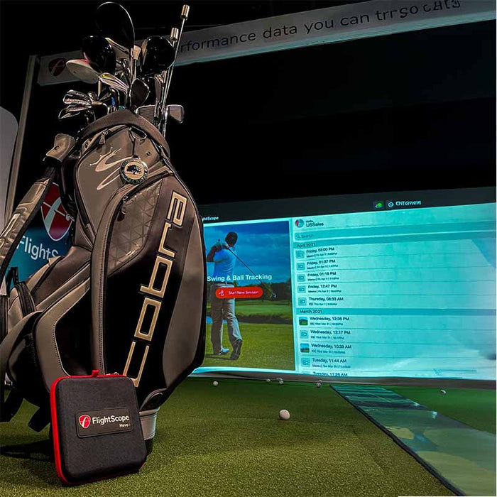 FlightScope Mevo+ monitor beside golf bag with simulation screen in the background.