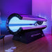 Modern MXP PowerBed Pro 100 red light therapy bed in a luxury spa setting, illuminated with blue and purple LED lights, promoting full-body light therapy and wellness recovery.