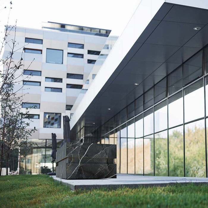 Luxurious black marble Nordic Vitality LOKI Ice Bath outside a high-end commercial building, combining cutting-edge wellness with modern architecture.