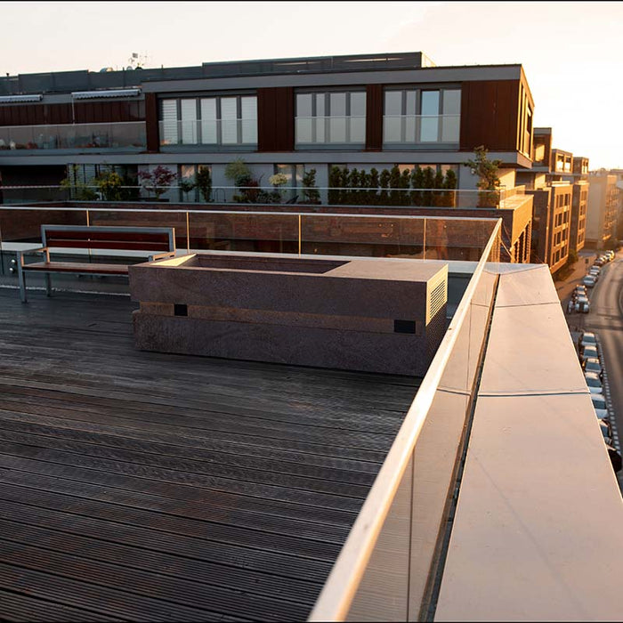 Rooftop Nordic Vitality LOKI Ice Bath in sunset light with a rust stone finish, placed on a city terrace for urban recovery and relaxation.