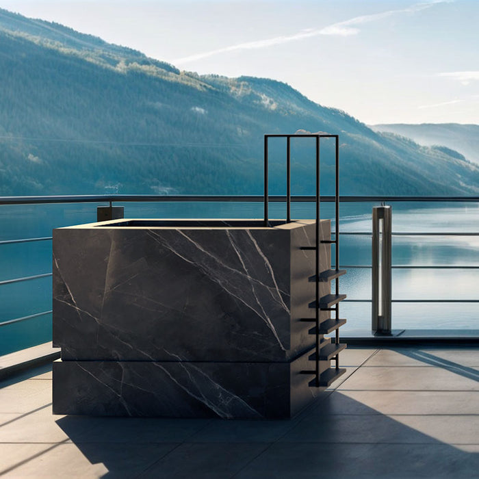 Nordic Vitality THOR Ice Bath in Calacatta Black marble-effect finish situated on a terrace with breathtaking lake and mountain views.