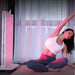 Nuvibody CORE 1500 red light therapy panel in use during yoga session with testimonial highlighting relief from skin, pain, and sleep issues.