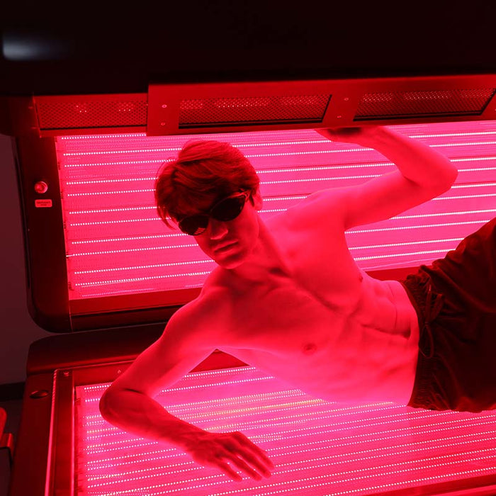 Male model using Nuvibody PRO red light therapy bed, demonstrating LED light exposure for body rejuvenation and wellness therapy.