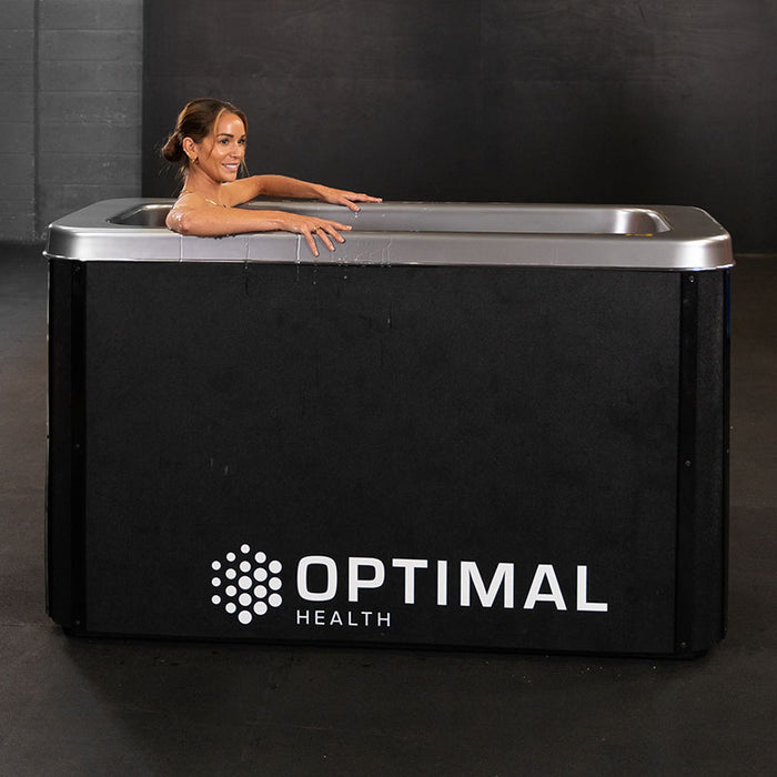 A woman is fully submerged in the Optimal Health Ice Bath, experiencing deep cold therapy for enhanced muscle recovery and inflammation relief.