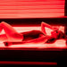 Female enjoying an immersive red light therapy session, absorbing infrared wavelengths for deep cellular rejuvenation and muscle recovery.