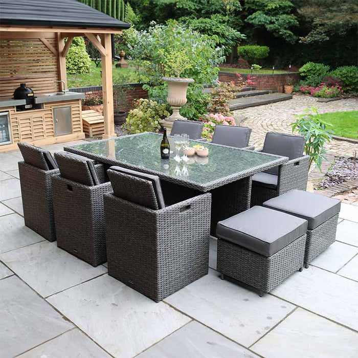 The Paris 10 Seater Cube Set in grey rattan, featuring a glass-topped table with cushioned chairs and stools, perfect for stylish outdoor dining.