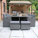 The Paris 10 Seater Cube Set, neatly arranged with chairs and stools tucked under the glass table, showcasing a space-saving design for garden use.