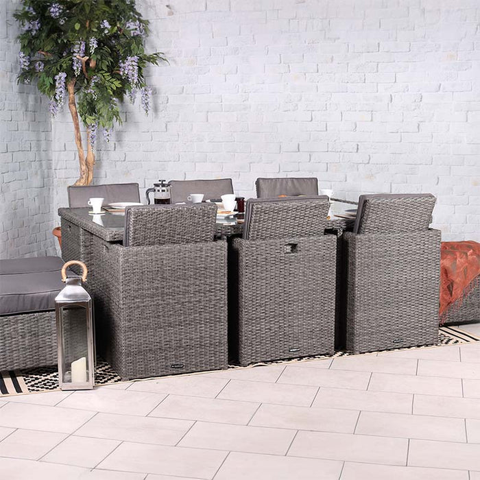 The Paris 10 Seater Cube Set arranged indoors, showcasing its grey rattan chairs and stools around a glass-topped table, perfect for stylish dining.