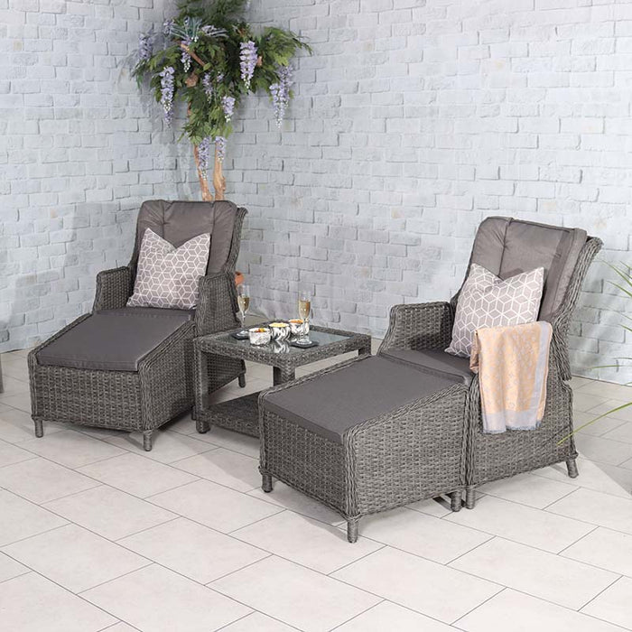 The Paris 2 Seater High Back Recliner Comfort Set is displayed in a bright indoor setting, complete with decorative pillows and drinks on the glass-top table.