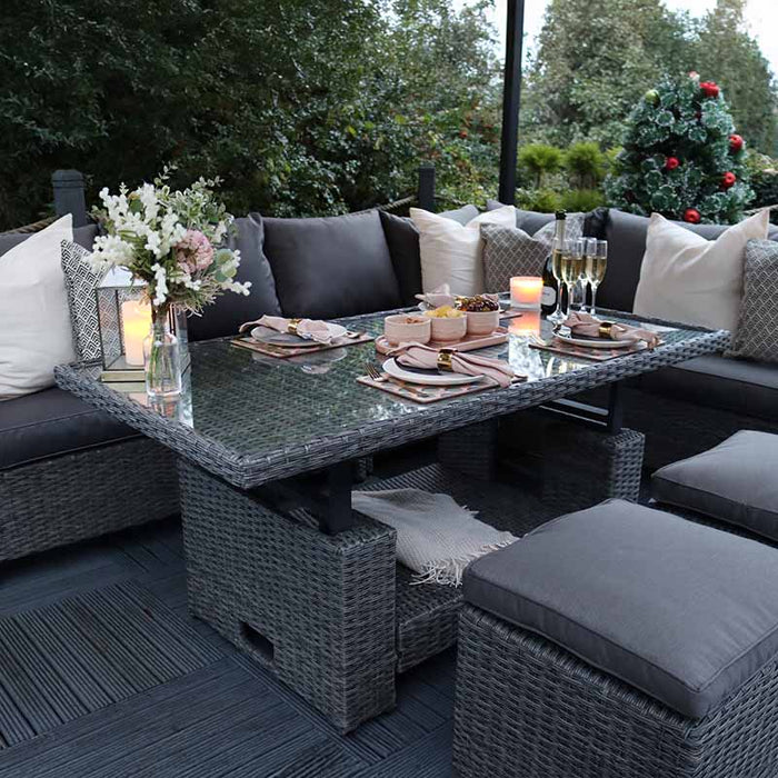 A lifestyle image of the Paris Deluxe Modular Corner Dining Set arranged outdoors in the evening, beautifully decorated for an intimate dinner setting.