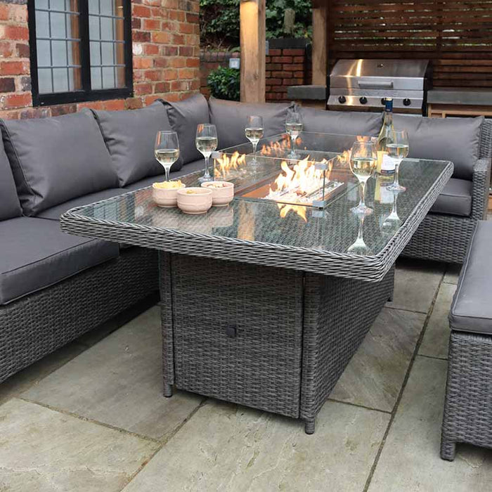 Paris Fire Pit Corner Dining & Lounge Set's rectangular table with the fire pit ablaze, creating a warm and inviting atmosphere for evening gatherings.