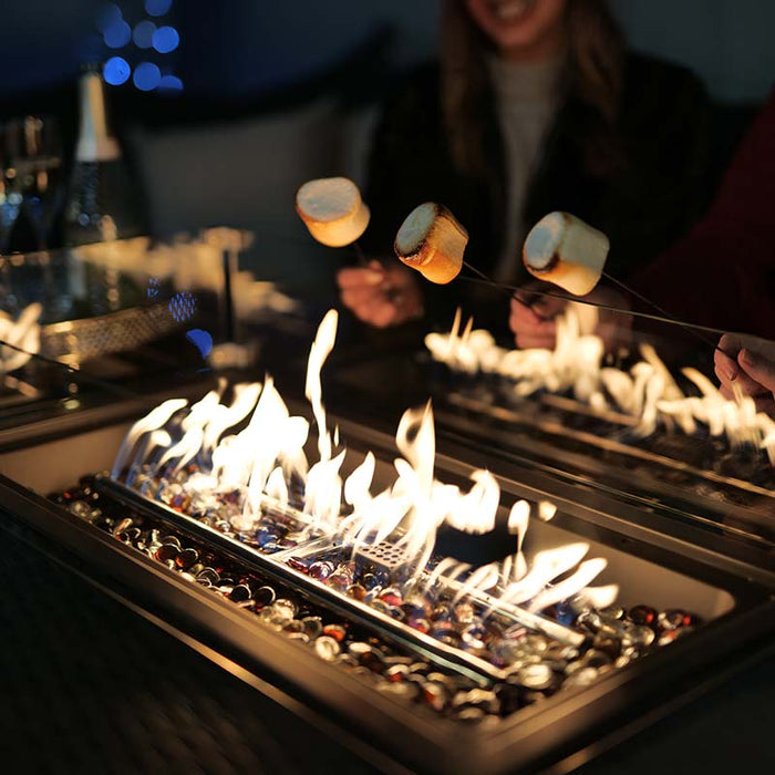 A cosy evening around the Paris Fire Pit Corner Dining & Lounge Set, roasting marshmallows over the vibrant fire pit.