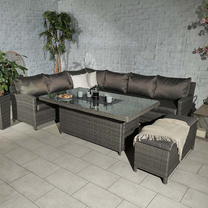 The Paris Fire Pit Corner Dining & Lounge Set arranged outdoors, featuring a spacious rectangular table and comfortable seating for an inviting outdoor space.