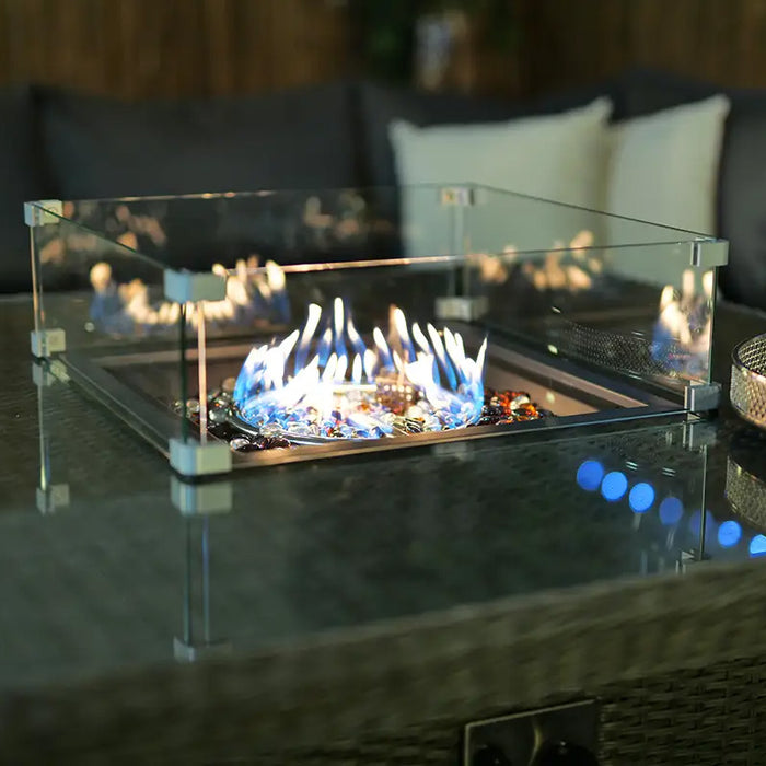 Glass-guarded fire pit in the Paris Fire Pit Dining Set, with flames dancing over the decorative stones.