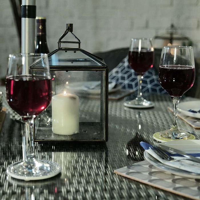 The Paris Imperial Round Dining Set tabletop adorned with a lantern and wine glasses, enhancing the dining experience with a warm and inviting ambiance.