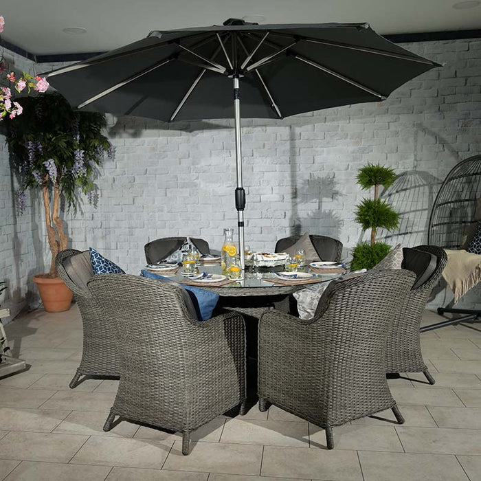 The Paris Imperial Round Dining Set paired with a grey parasol, creating a sophisticated outdoor dining experience.