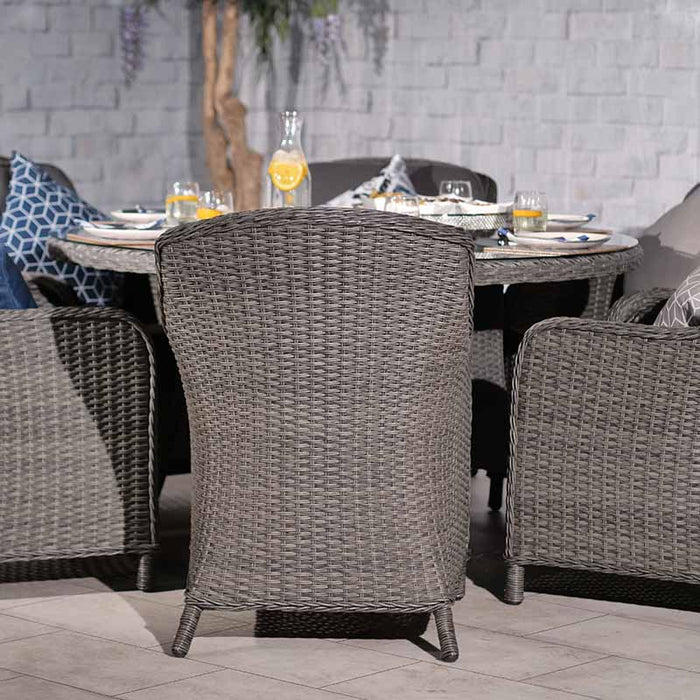 Outdoor dining setup featuring the Paris Imperial Round Dining Set with a large parasol, offering shade and style for any garden space.