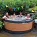  Family smiling in a hot tub with festive bunting in a lush garden