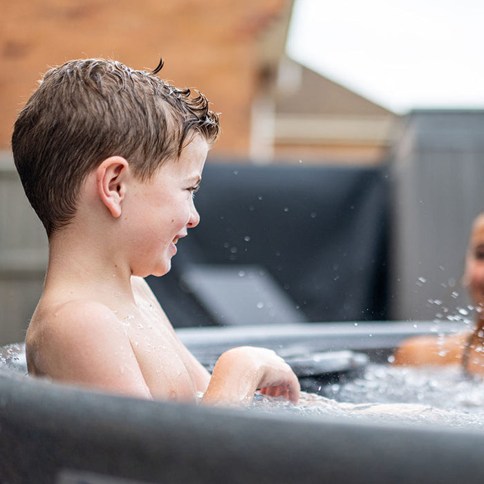 Family enjoying water play and wellness together in the Rotospa Orbis Hot Tub.