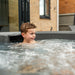 Child enjoying bubble jets and warm water fun inside the Rotospa Orbis Hot Tub.