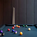 RS Barcelona Diagonal outdoor pool table playing surface with colourful billiard balls, modern pool table felt detail with cues in background.