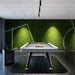 RS Barcelona Diagonal outdoor pool table in white with wooden legs in modern games room with green wall, stylish billiard table setting.