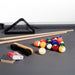 Close-up of RS Barcelona Diagonal pool table accessories including billiard balls, cue sticks, triangle rack and chalk on grey cloth.