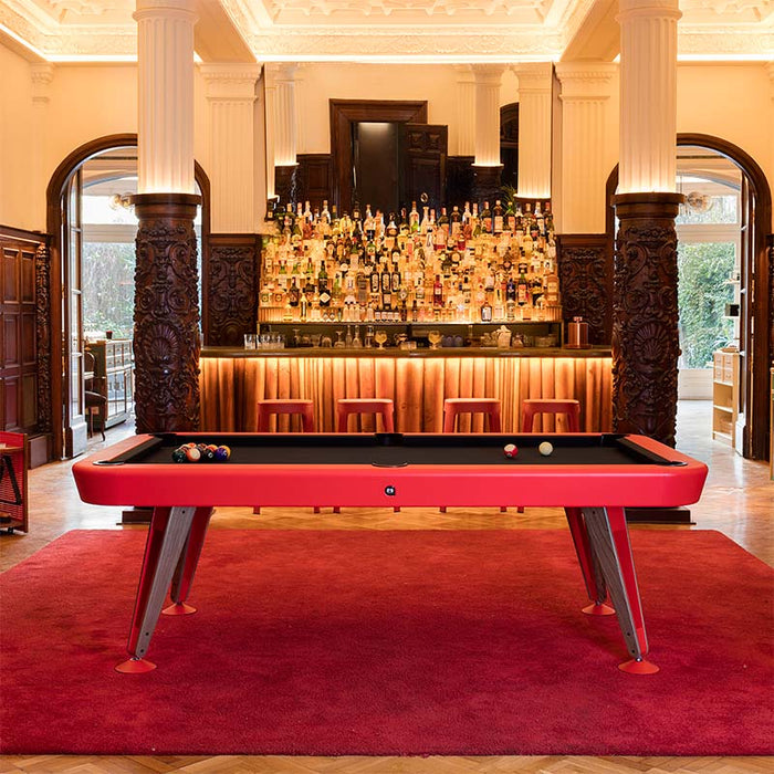 RS Barcelona Diagonal pool table in red finish positioned in a luxury bar interior with wooden columns and elegant lighting.