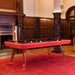 RS Barcelona Diagonal pool table in red finish placed in elegant interior with wooden panelling and red carpet.