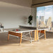 RS Barcelona folding table tennis table in stylish indoor space with city view, featuring white tabletop, wooden legs and modern net system.