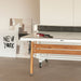 RS Barcelona folding table tennis table detail showing smooth white playing surface, wooden frame and net with paddles and ball for indoor ping pong use.