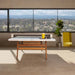 RS Barcelona ping pong table with white top and wooden legs in a stylish loft interior with large windows and natural light.