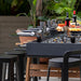 RS Barcelona RS MAX dining football table styled for outdoor dining with stools, wine, cheese and charcuterie in a modern garden patio.